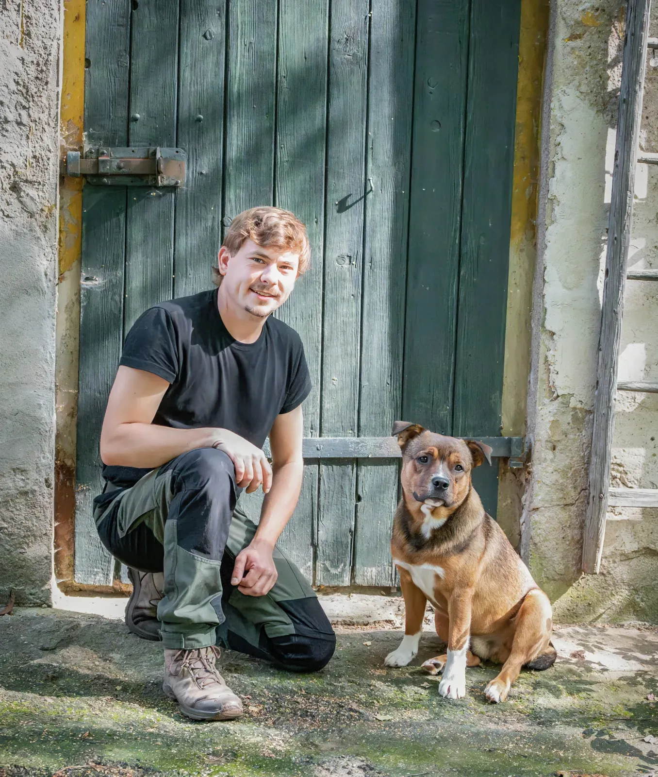 Jonas und Hofhund Alfred vor einer alten Holztür