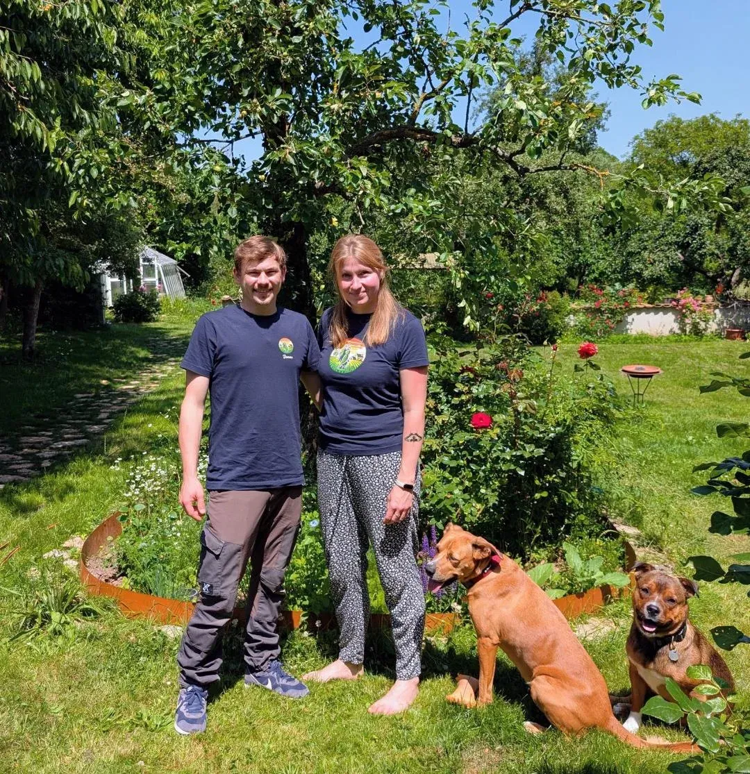 Paula und Jonas mit ihren beiden Hunden im Garten des Schmücke-Hofs