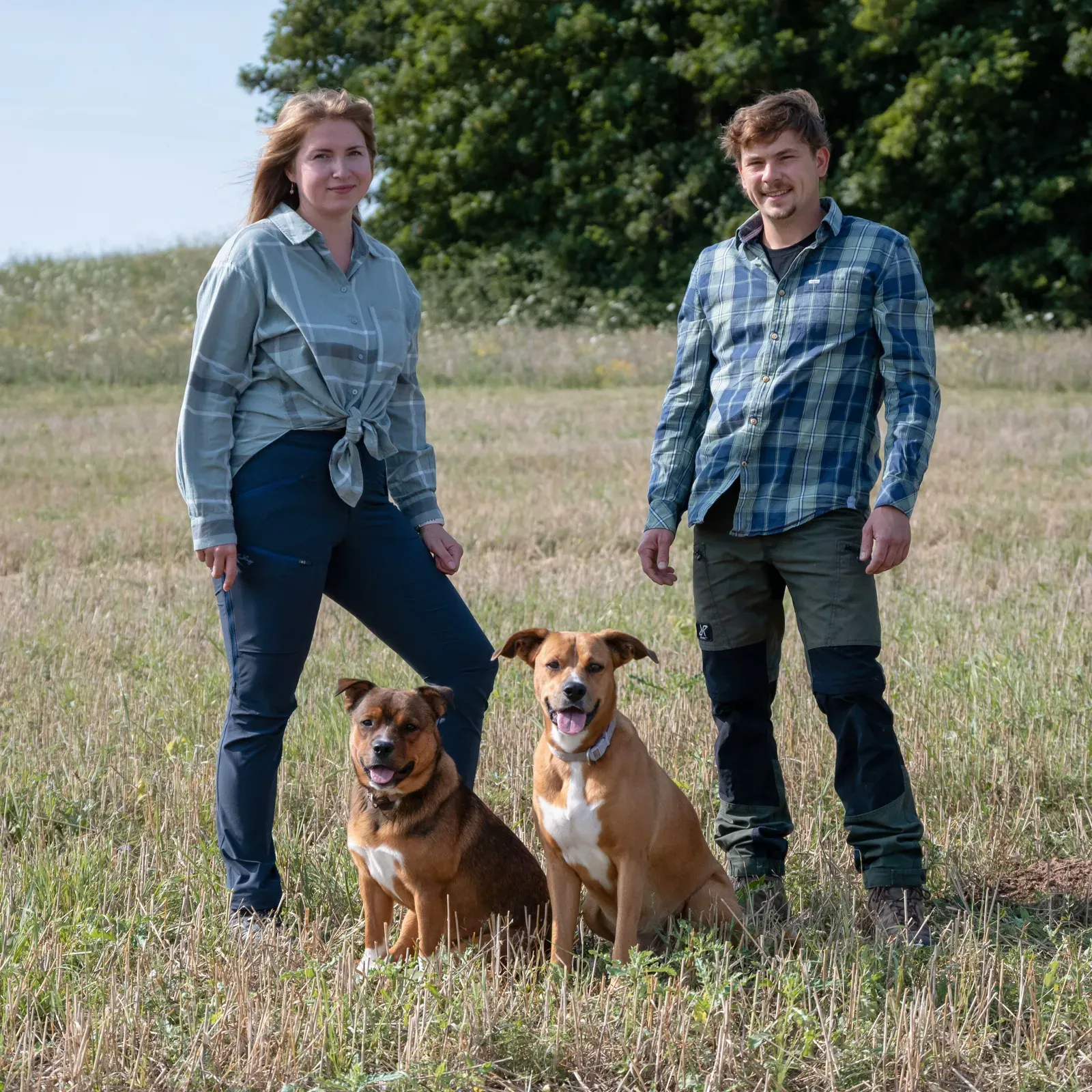 Paula und Jonas mit den Hunden Alfred und Betty auf einer Wiese