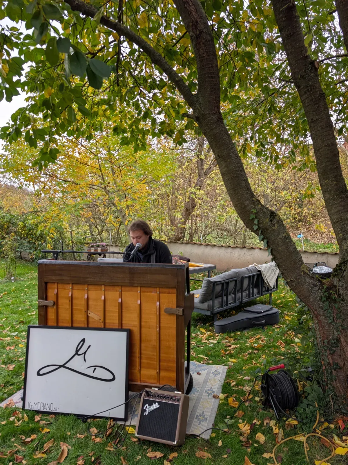 Klavier unter einem Baum im Garten beim Hoffest