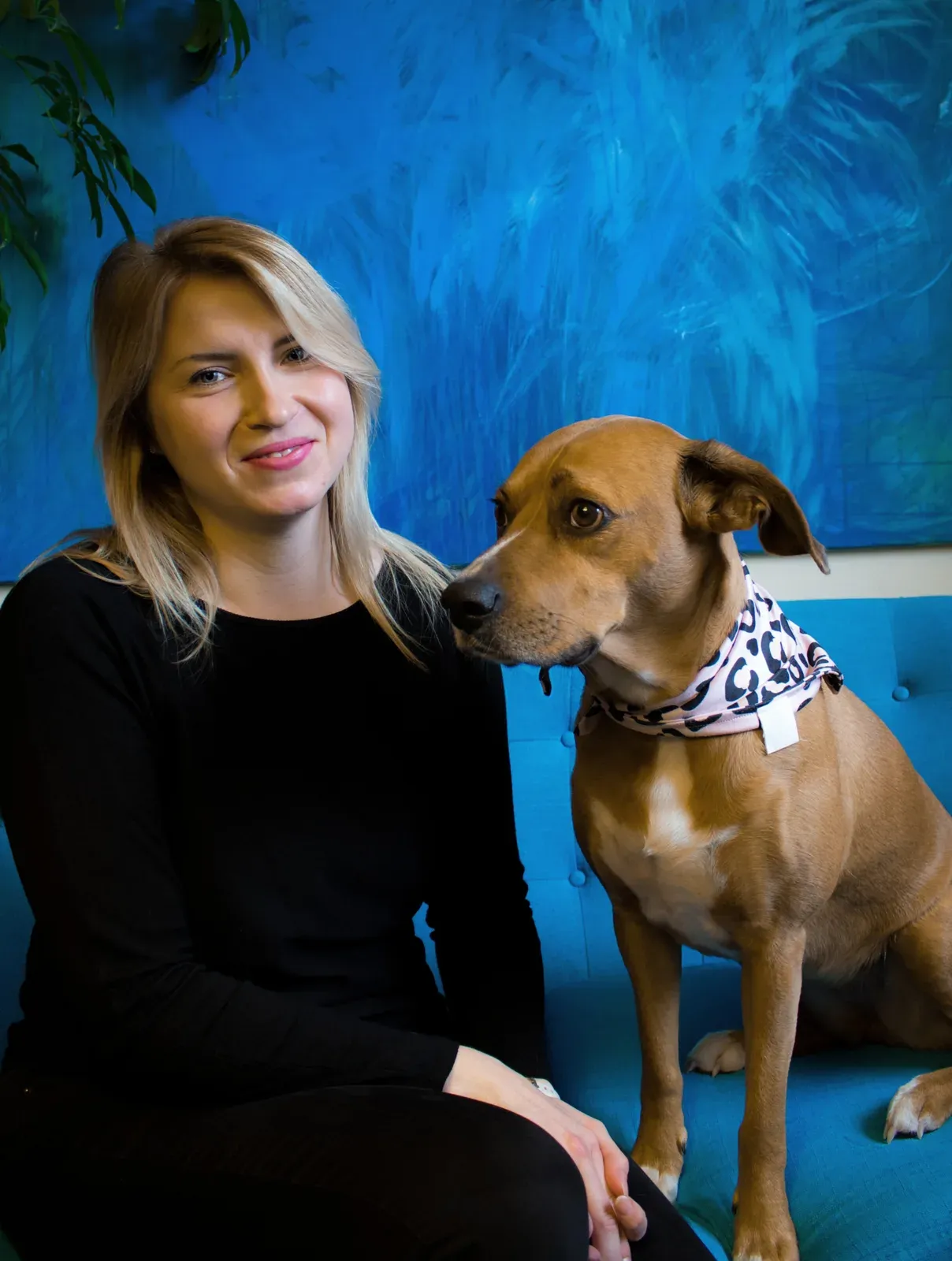 Paula mit Hündin Betty vor einem blauen Hintergrund